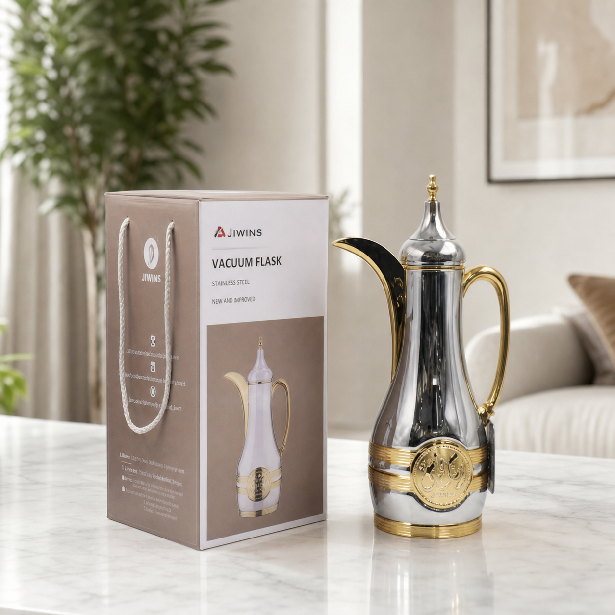 Silver and gold dallah serving pot on a marble table beside its printed gift carton