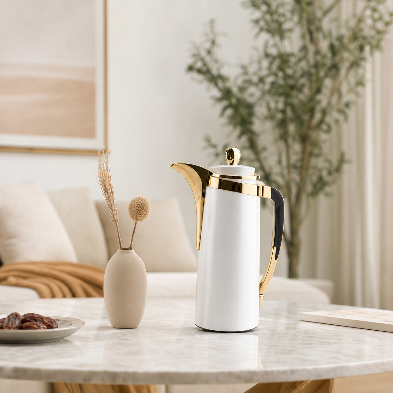 White and gold-tone dallah coffee flask styled on a marble side table