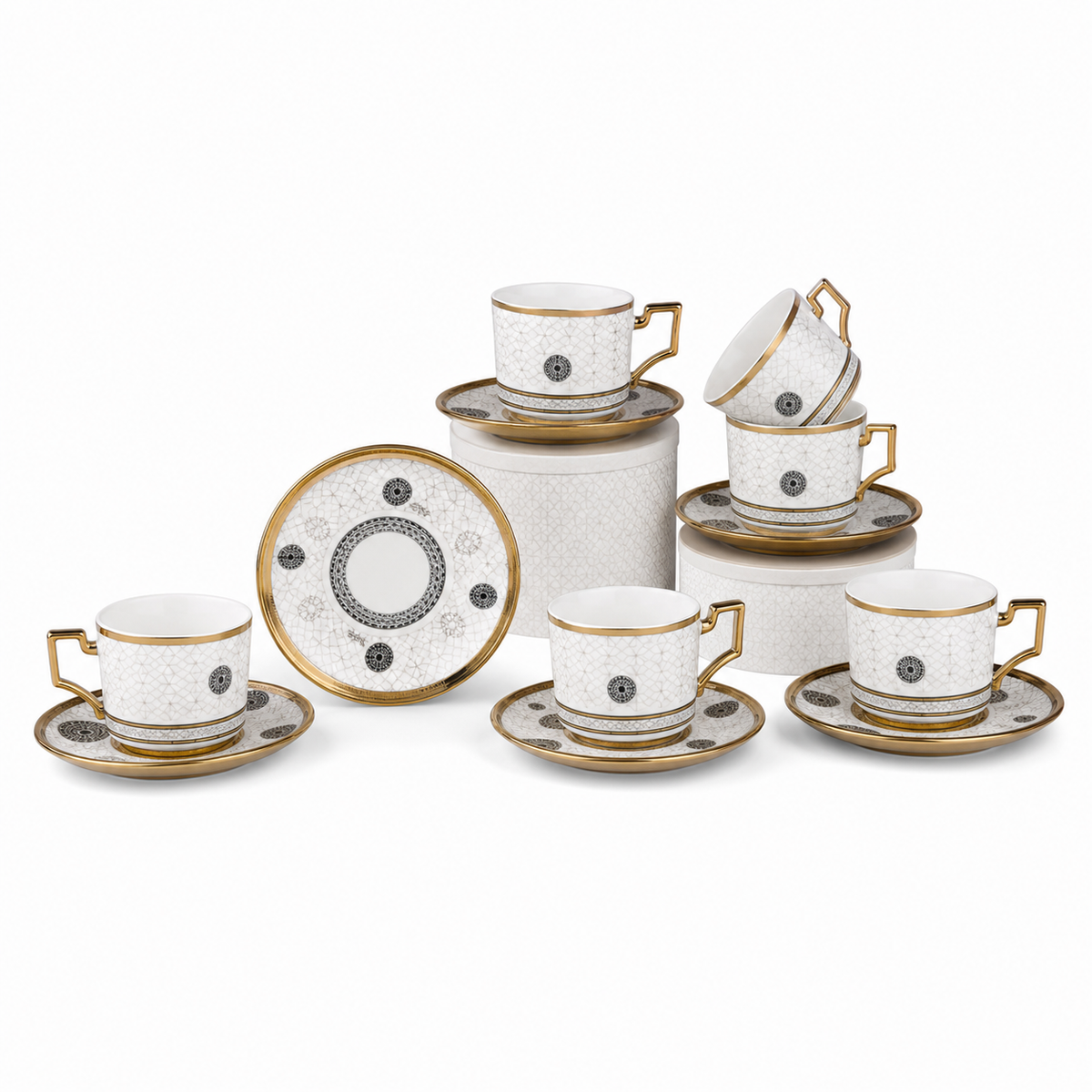 White porcelain coffee cups and saucers with gold rims and black medallion motifs