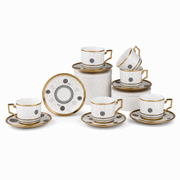 White porcelain coffee cups and saucers with gold rims and black medallion motifs