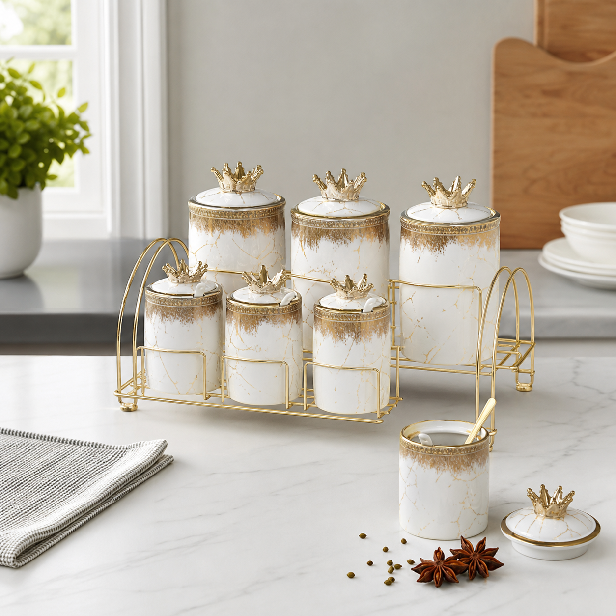 White and gold marbled ceramic canister set with crown lids on a gold-tone kitchen stand