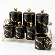 Black and gold ceramic spice and seasoning jar set on a gold-tone rack