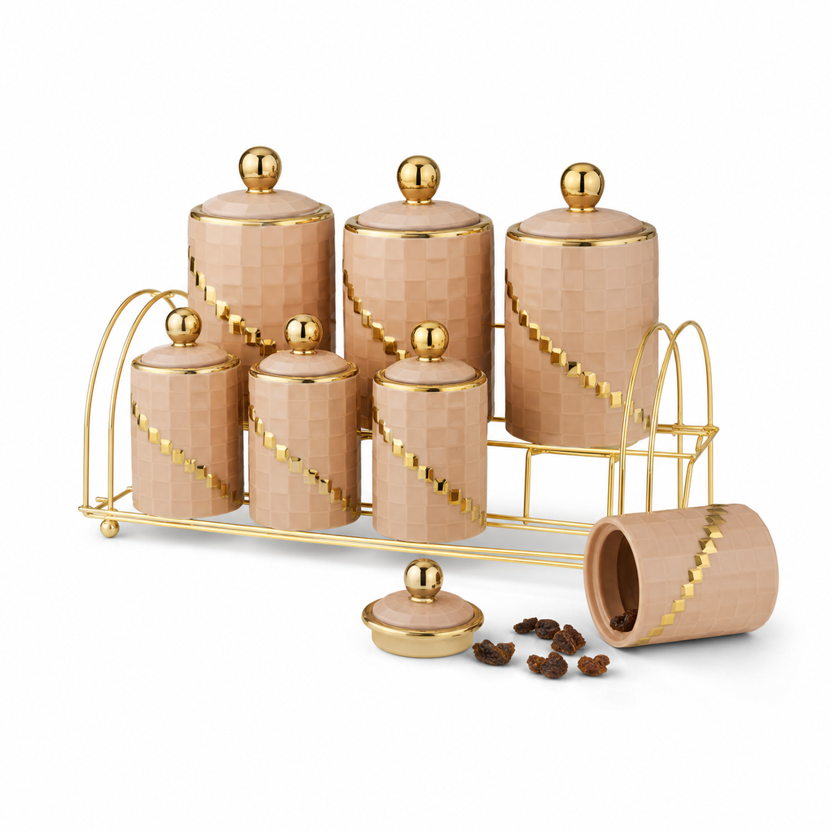 Beige ceramic spice jar set with gold ball-knob lids and a diagonal band of gold studs, on a gold-tone rack