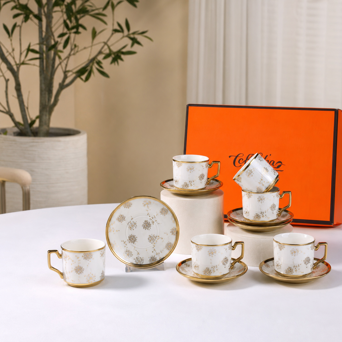 White ceramic coffee set of six cups and six saucers with gold-tone rims and a gold medallion pattern