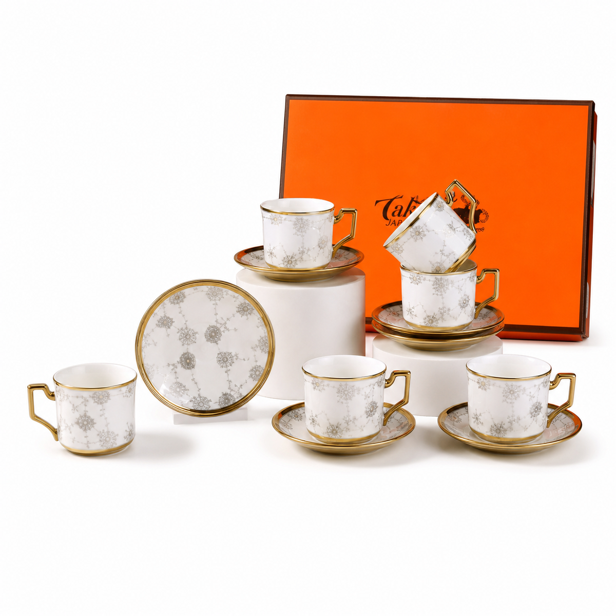 Twelve-piece white ceramic coffee set: six cups, six saucers, gold-tone rims, silver-grey medallion pattern