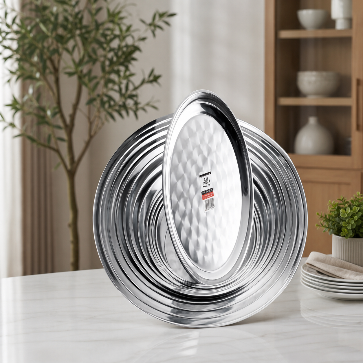 Stack of stainless steel round plates and an oval platter on a dining table
