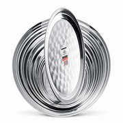 Nested mirror-polished stainless steel round plates with an oval platter in front