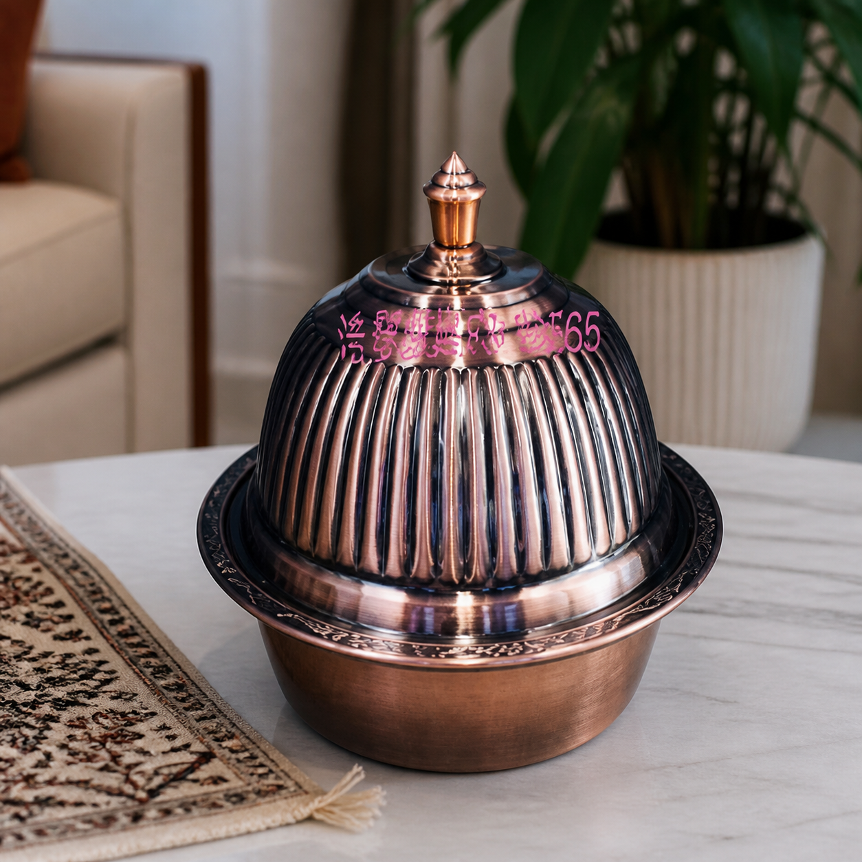 Copper-tone covered serving bowl with ribbed domed lid and finial, on a marble table