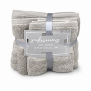 Three-piece beige terry towel set, folded and banded with a grey ribbon, on a white background
