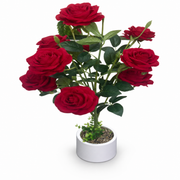 Red artificial roses arranged in a white vase