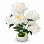 White and ivory artificial peonies arranged in a white vase
