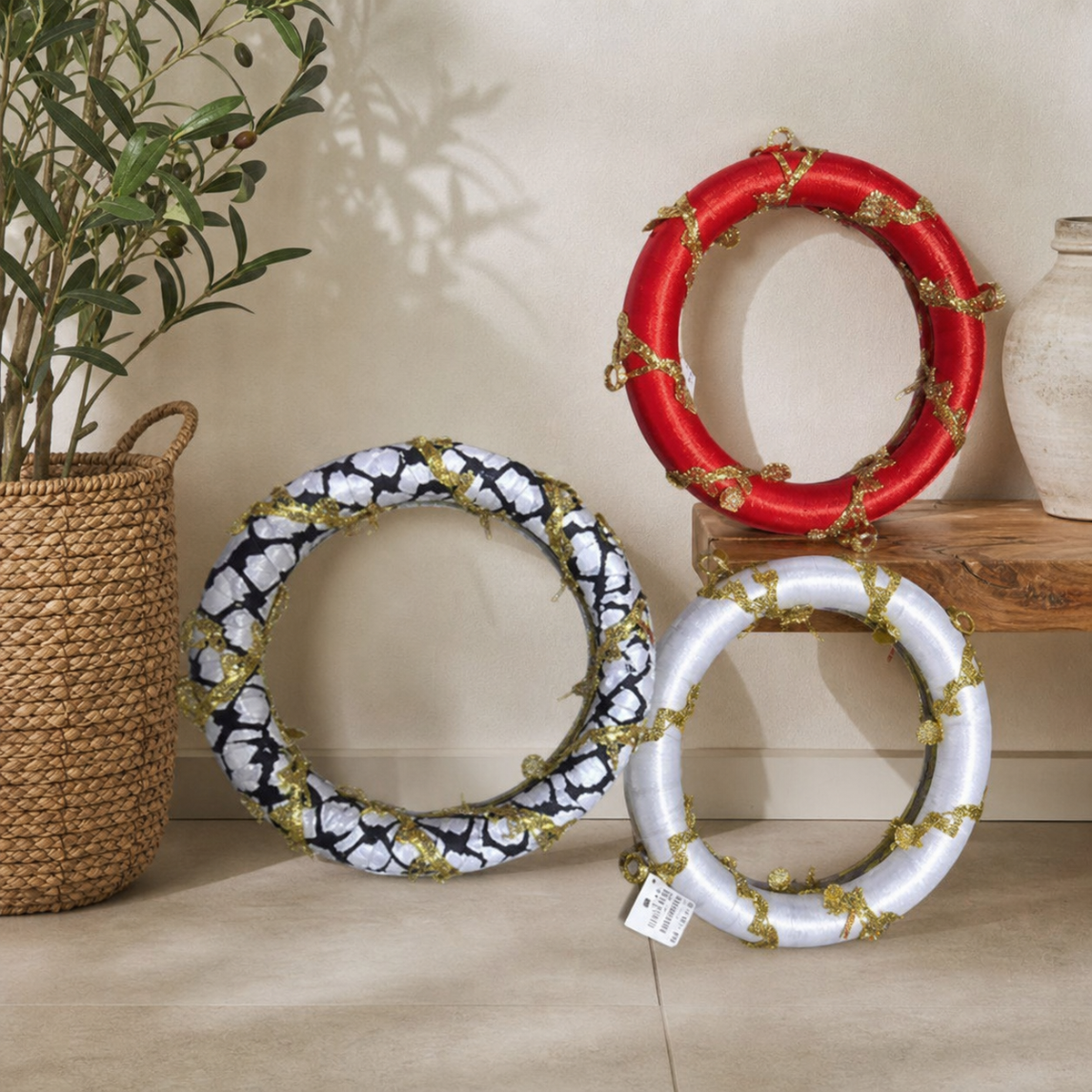 Black-and-white, red and white beaded ring ornaments leaning by a wooden bench and potted plant