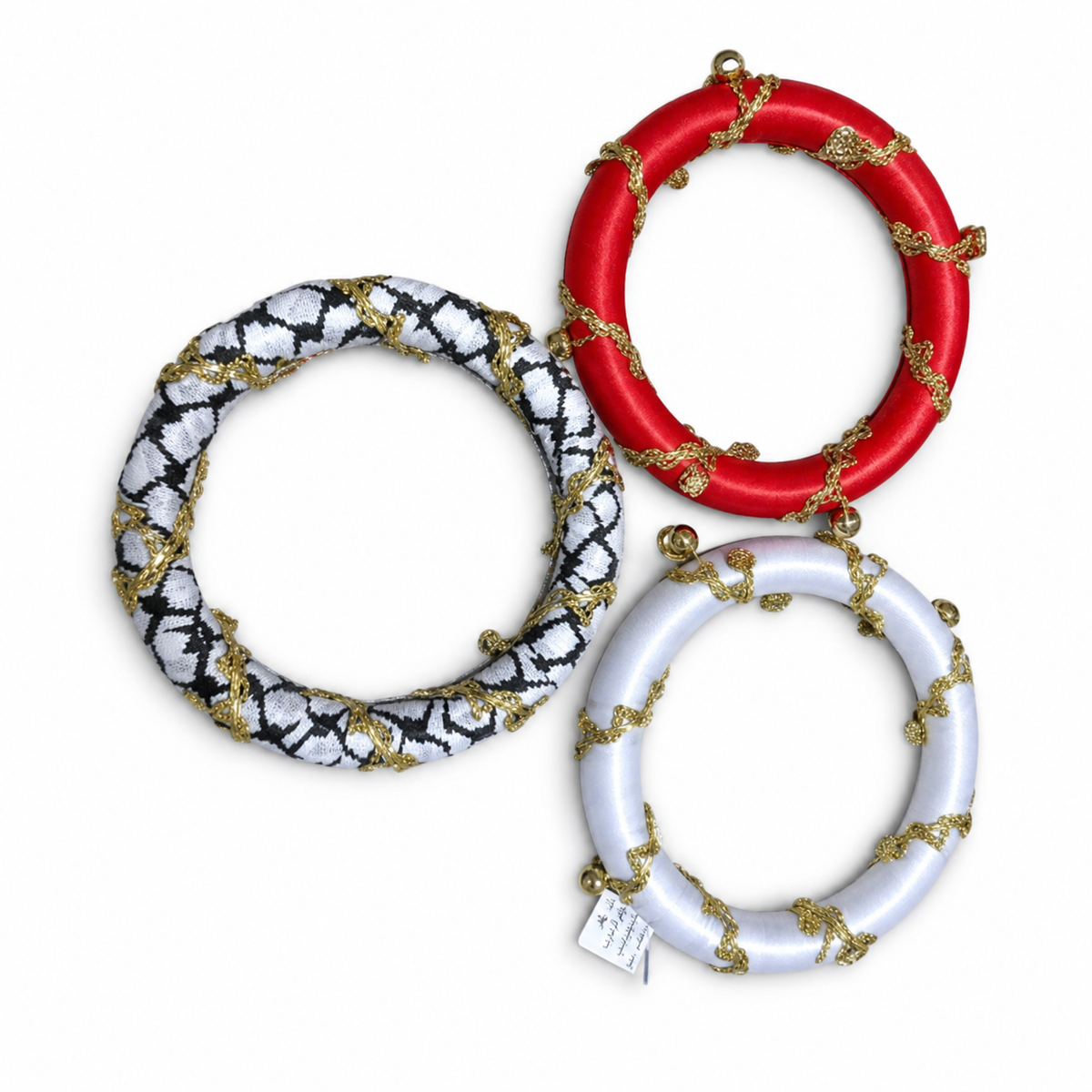Three satin-wound ring ornaments with gold cord and small gold beads, in black and white, red and white