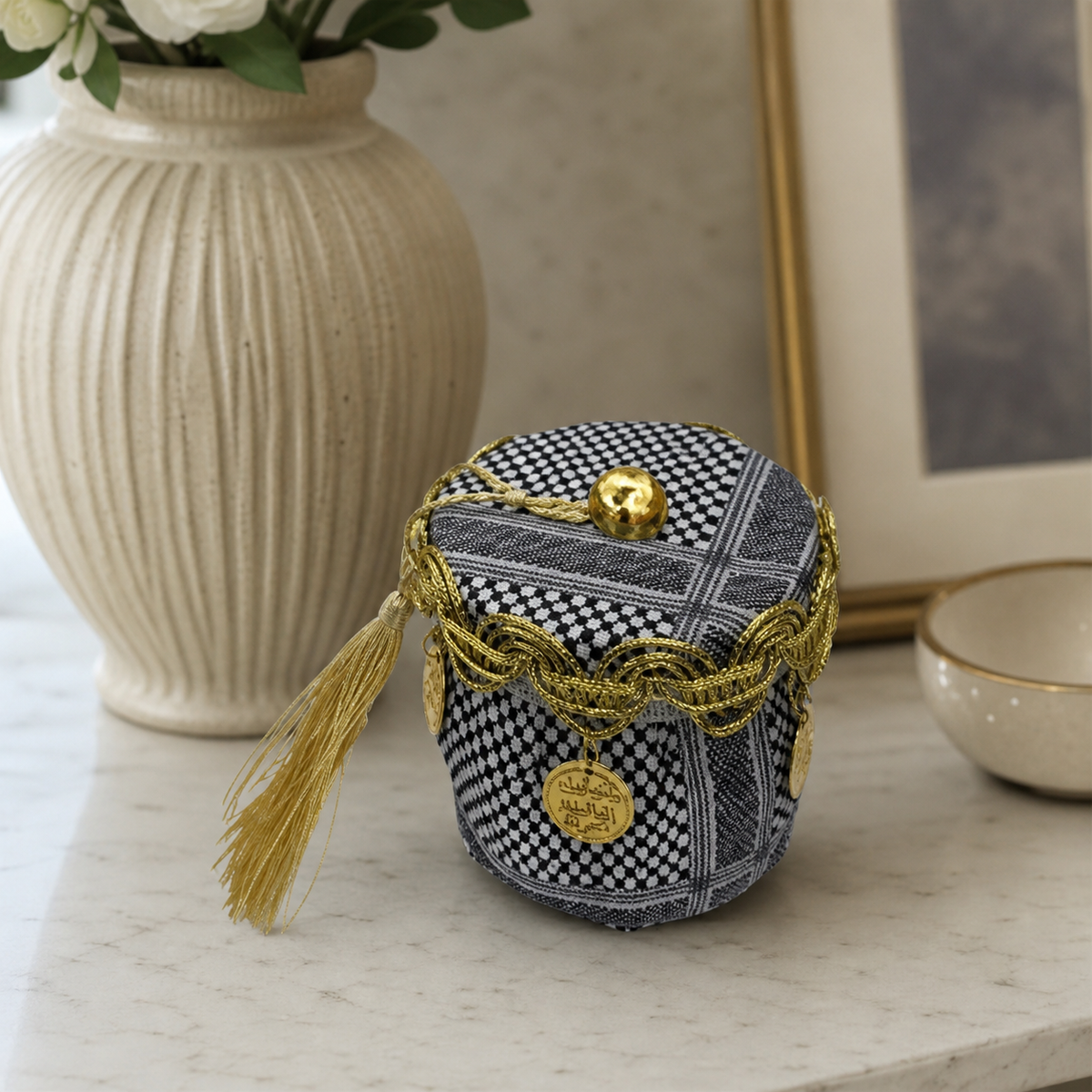 Keffiyeh-print favor basket in black and white with gold-tone coins and tassels