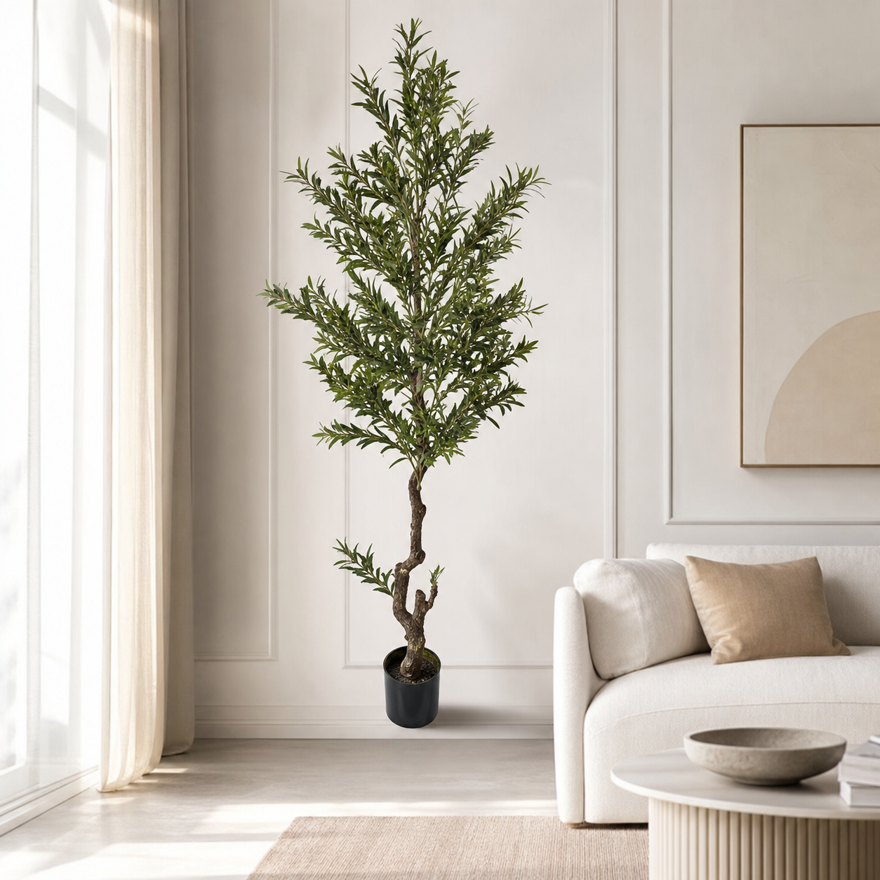 Artificial tree with narrow green leaves in a black pot, beside a sofa in a bright living room