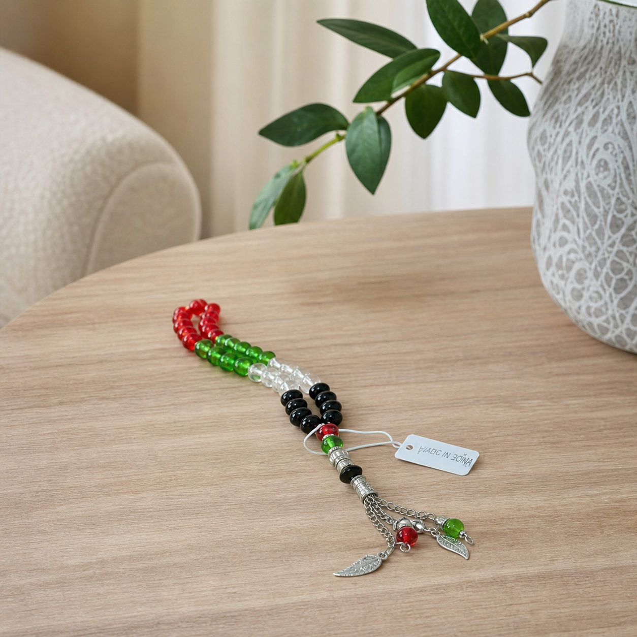 Multicolour tasbeeh strand with silver-tone tassel on a wooden table