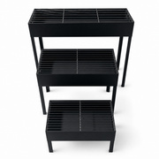 Three black rectangular charcoal grills of graduated size on straight legs