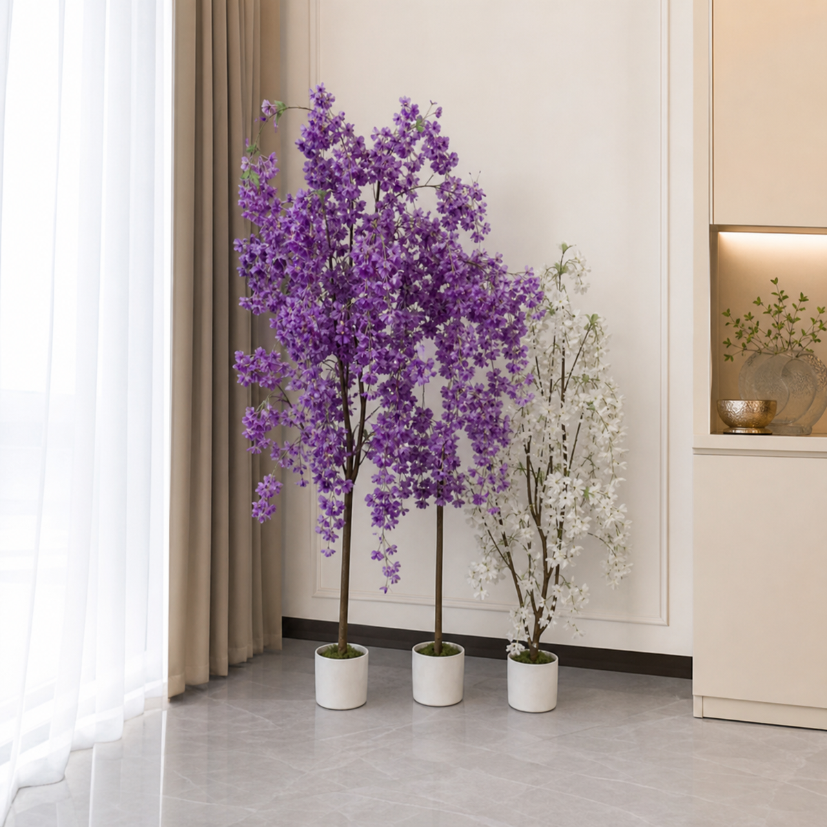 Two purple artificial blossom trees and a shorter white blossom tree in cream pots in a room corner