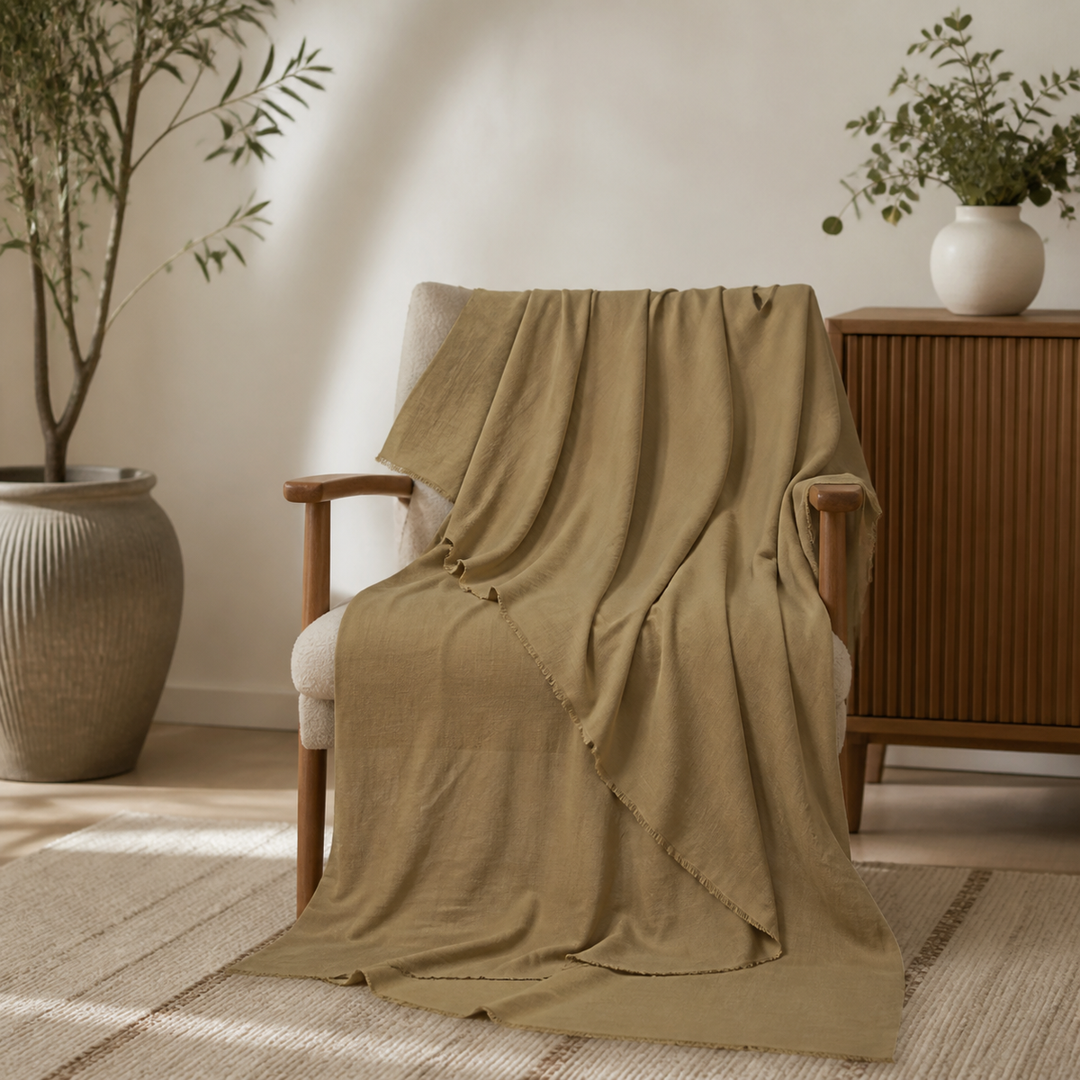 Khaki scarf draped over a wooden armchair and pooling onto the rug in a living room setting