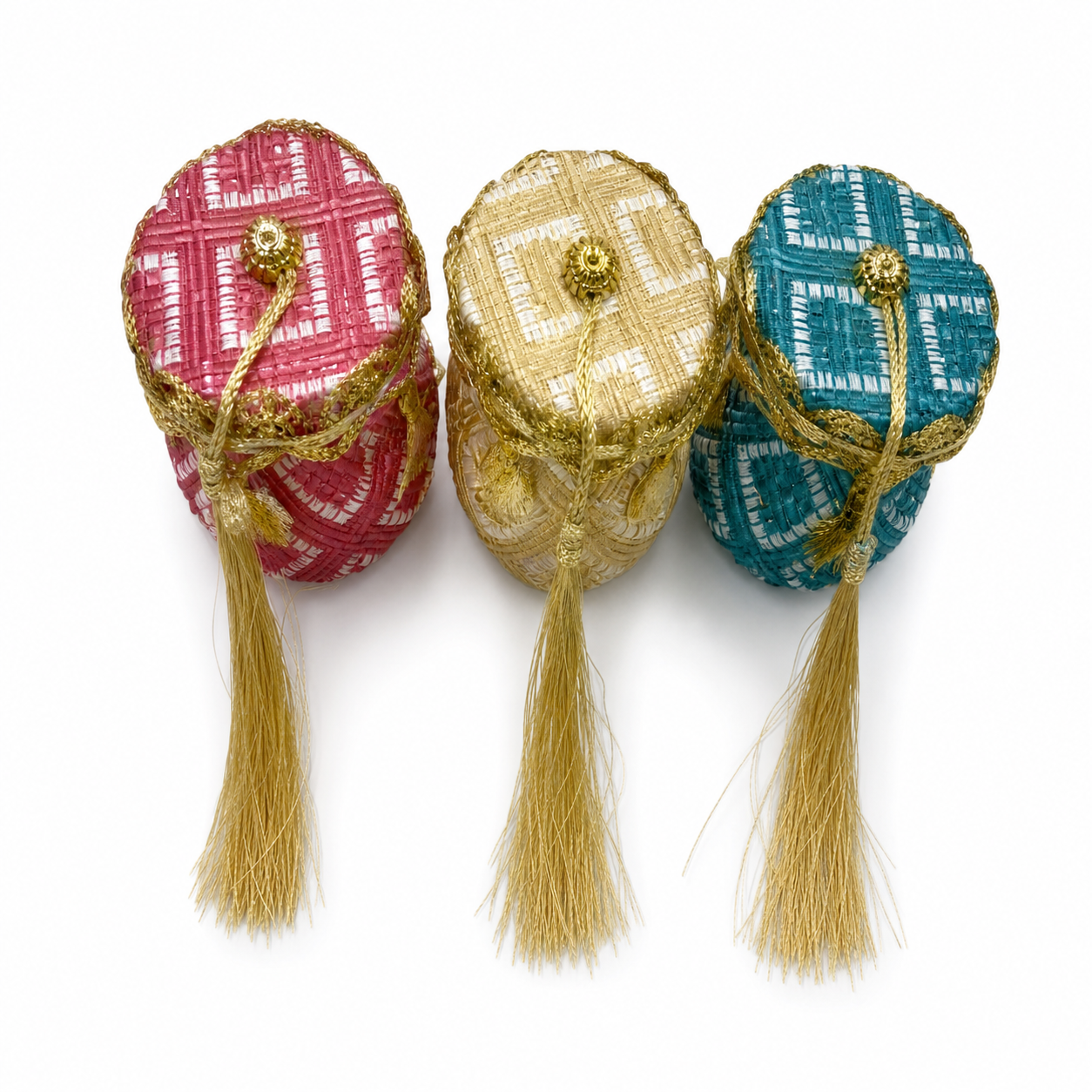 Three lidded pots in woven pink, gold and teal basket-weave, each with a gold-tone cord and long tassel