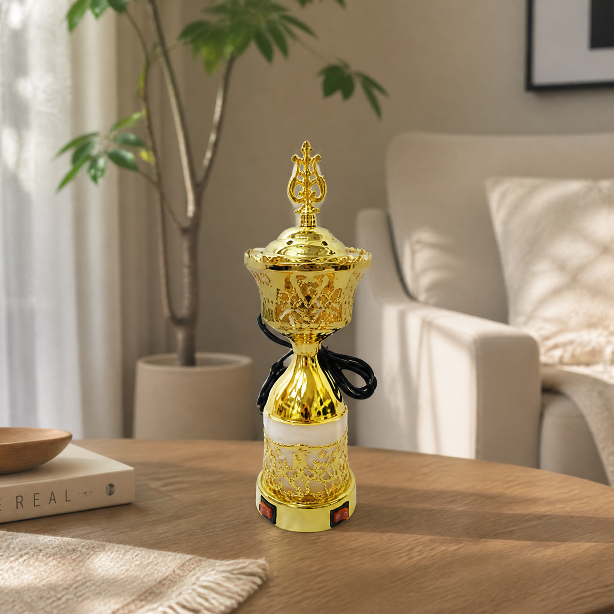Gold and white electric incense burner with spire finial on a wooden table