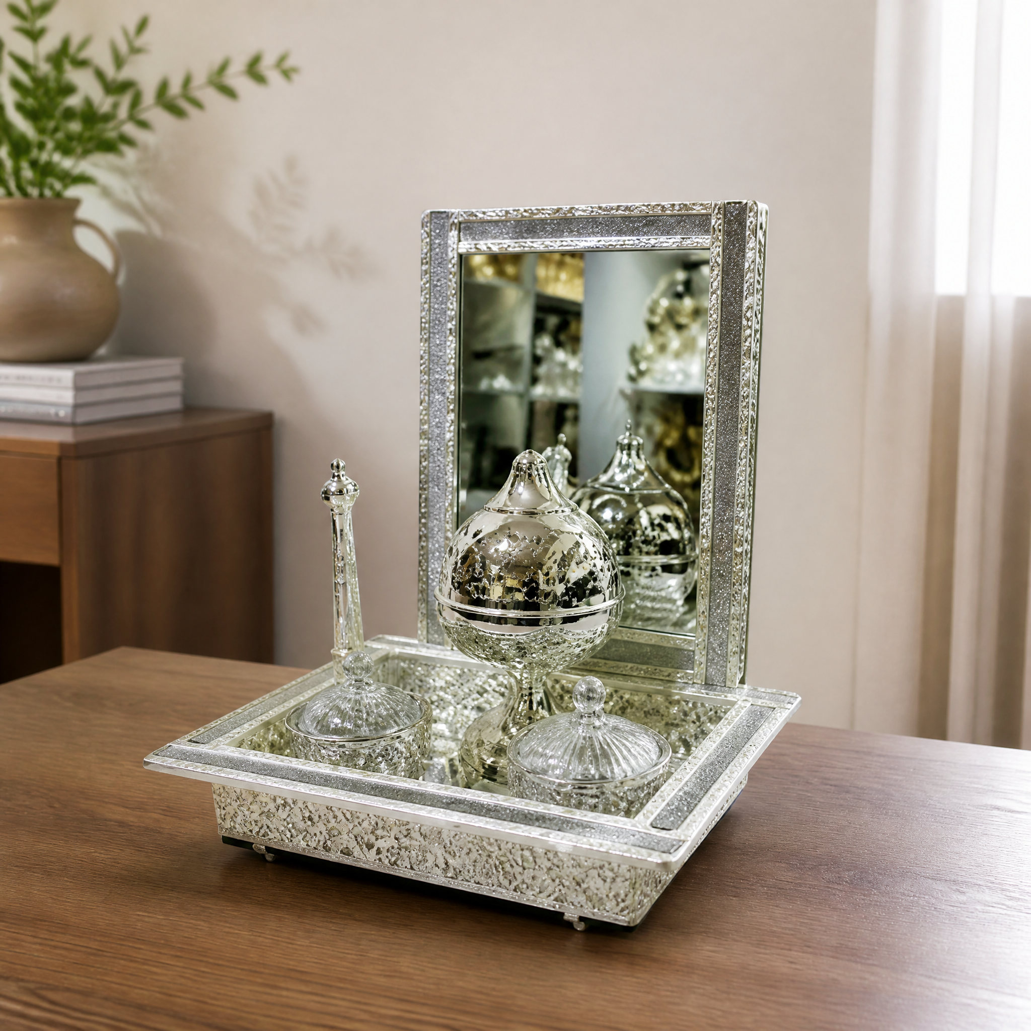 Silver mirrored burner set styled on a wooden tabletop in a neutral room setting
