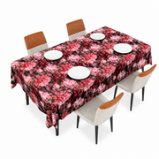 Rose-print table covering in pink and red, spread over a rectangular dining table set with four white plates