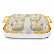 Rectangular silver tray with gold handles holding four ribbed glass bowls with gold-rimmed lids