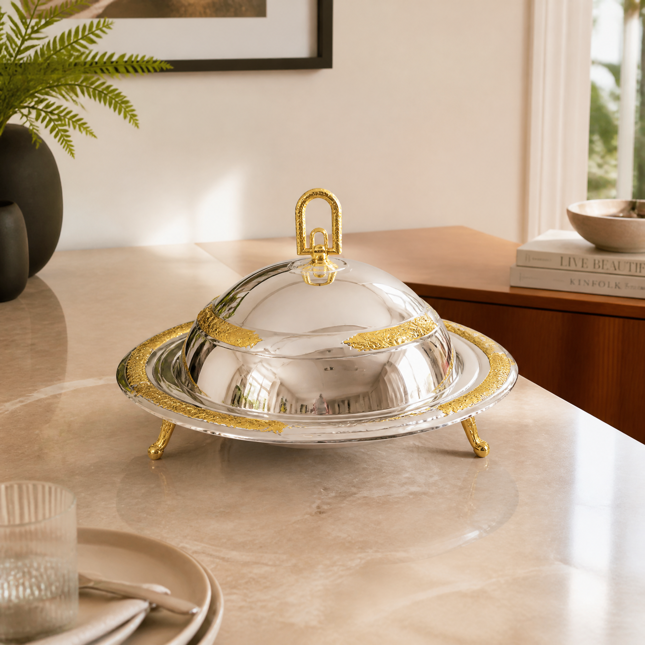 Footed silver and gold food warmer with domed lid and gold carry handle