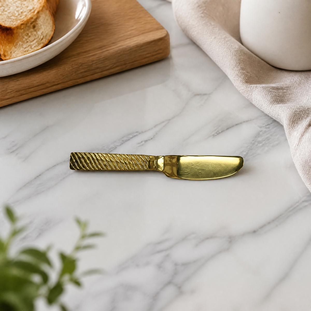 Gold-tone butter knife on a marble counter beside a plate of toast