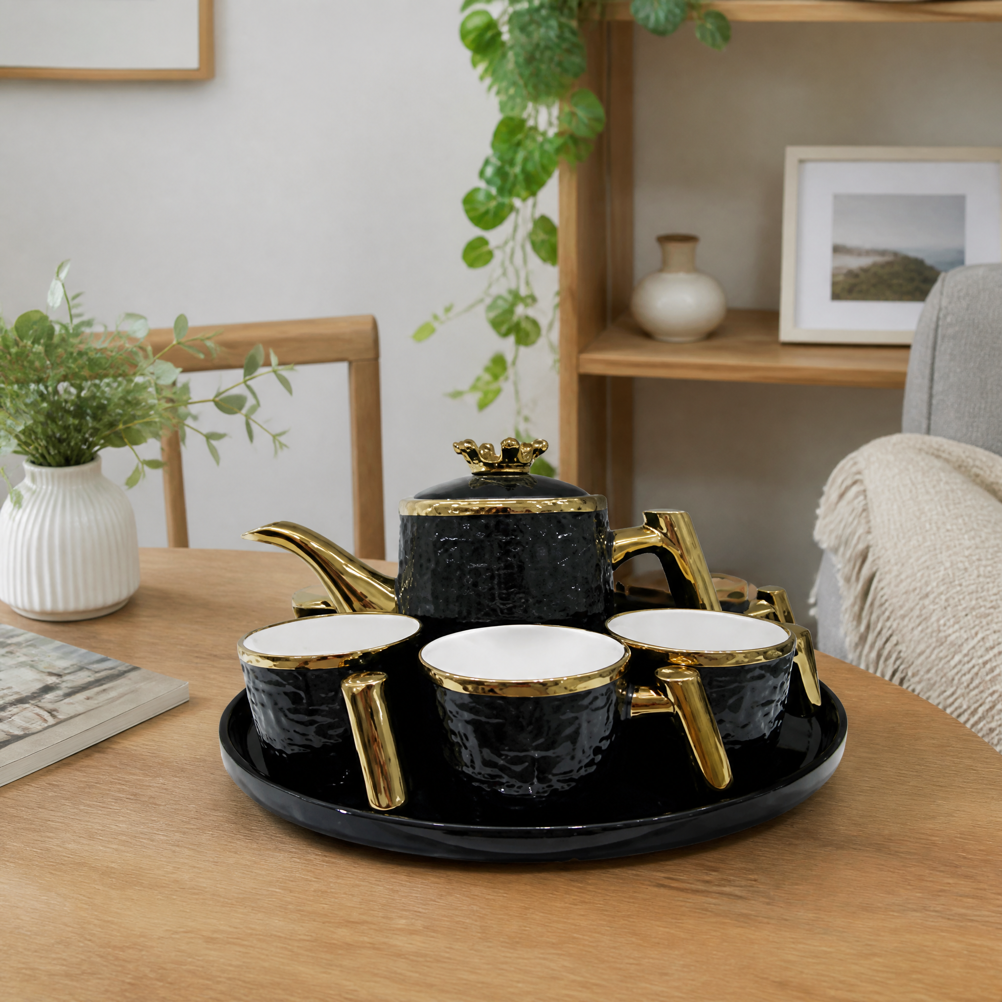 Black tea service with gold trim: lidded teapot cups and an oval tray