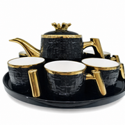 Black tea service with gold trim: lidded teapot cups and an oval tray