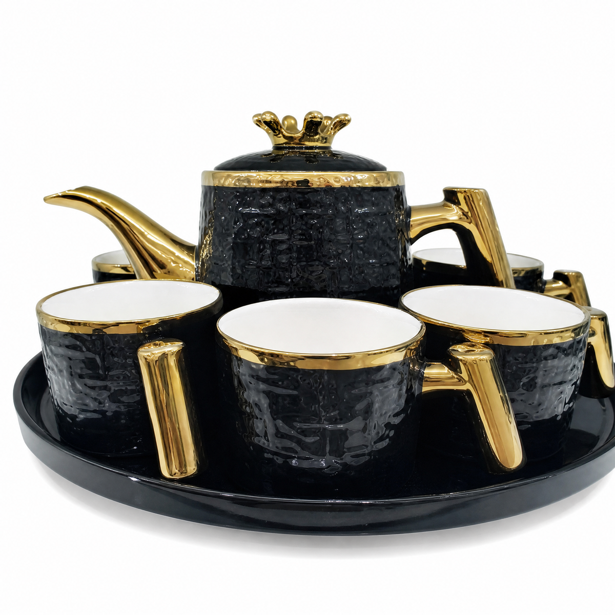Black tea service with gold trim: lidded teapot cups and an oval tray
