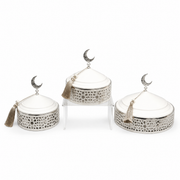 Three graduated white and silver domed serving dishes on a filigree base