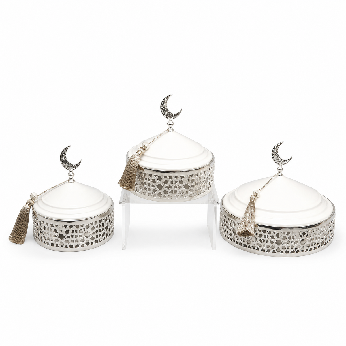 Three graduated white and silver domed serving dishes on a filigree base