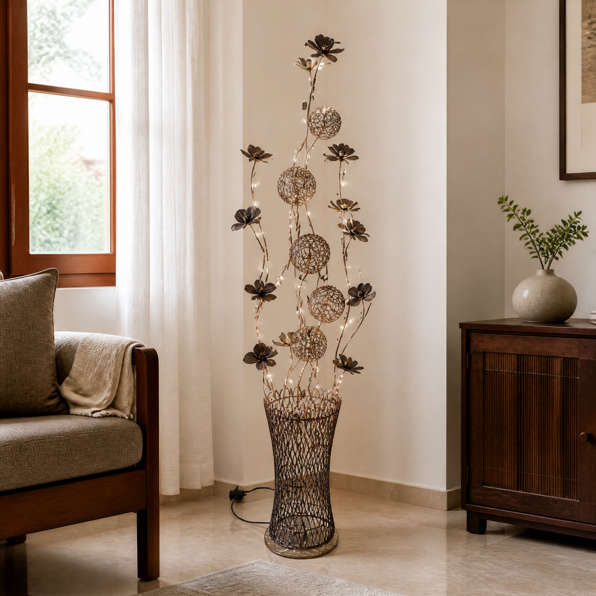 Floral wire floor lamp lit by fine LED strands, standing beside a sofa in a living room