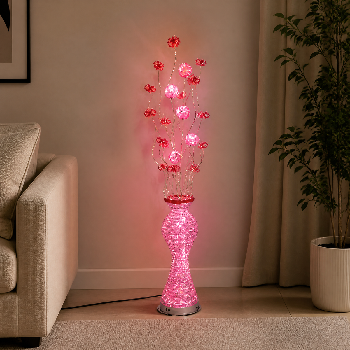 Pink LED floral floor lamp lit in a living room, glowing vase base beside a sofa and plant