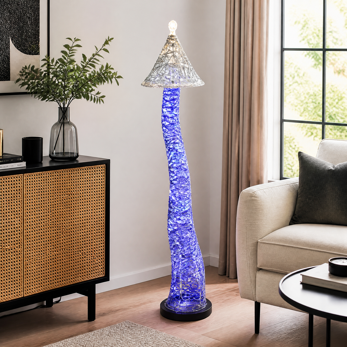 Blue LED tower floor lamp lit beside a sofa, conical wire shade glowing at the top