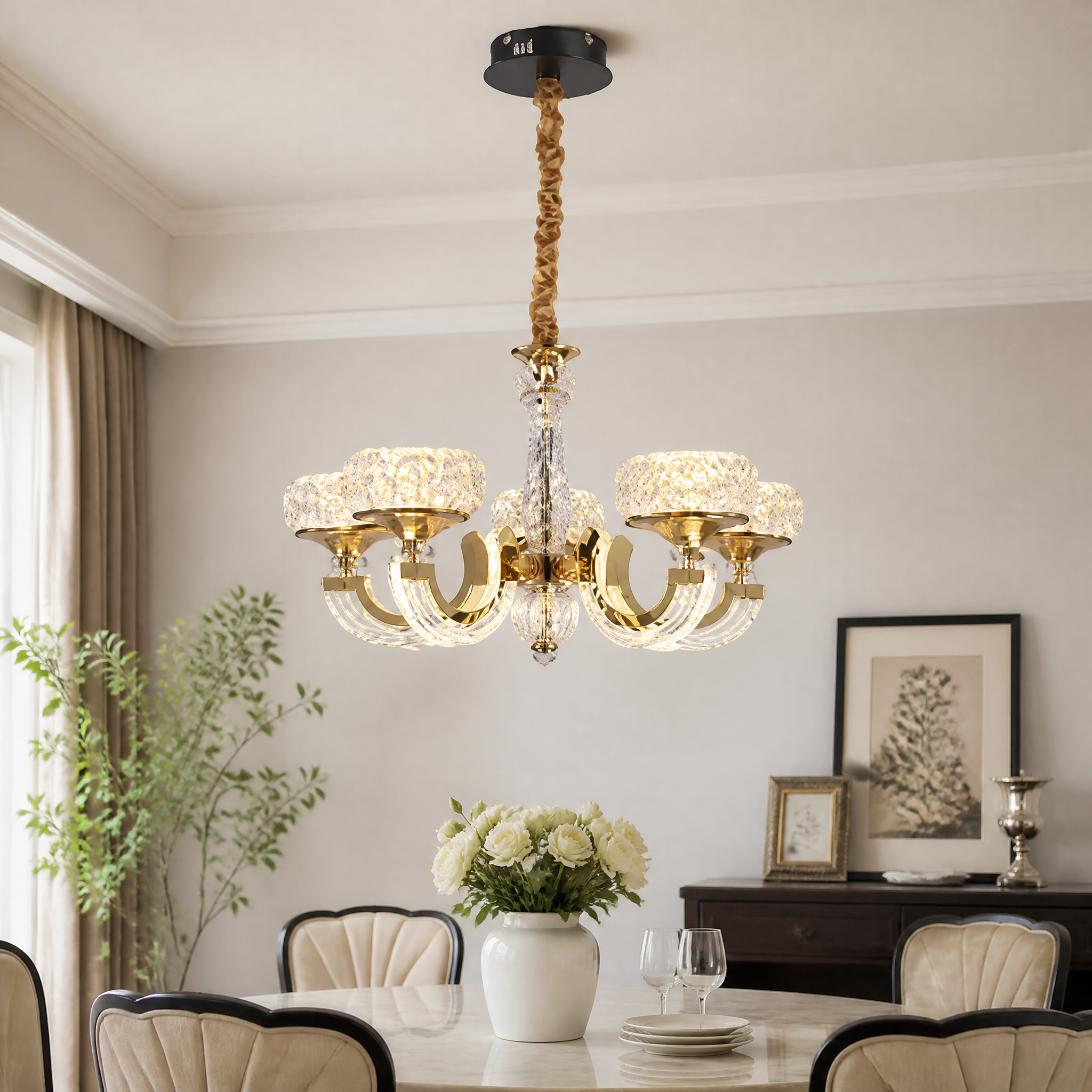 Gold candelabra chandelier lit above a dining table, five crystal shades on curved arms